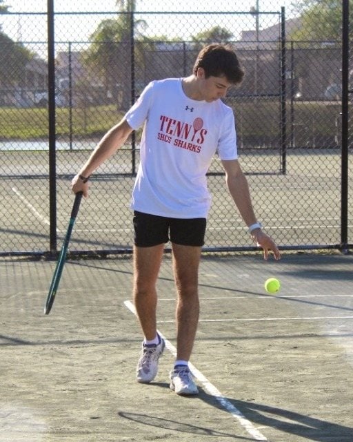 Coach Matheus preparing to serve on a tennis court